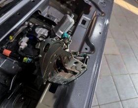 Механизм замка нижней крышки багажника Lexus LX450d в процессе ремонта электропривода