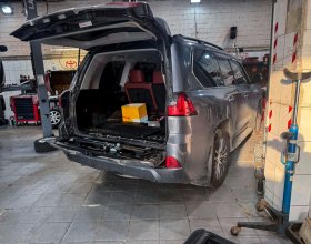 Lexus LX450d с открытой верхней и разобранной нижней крышкой багажника во время ремонта электропривода