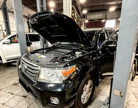 Toyota Land Cruiser 2015 года с открытым капотом в ремонтной зоне перед заменой корпуса топливного фильтра